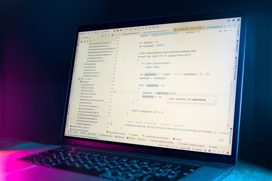 A close-up of a computer monitor displaying lines of colorful programming code with syntax highlighting, including keywords, variables, and functions in shades of blue, pink, green, and white. The bac
